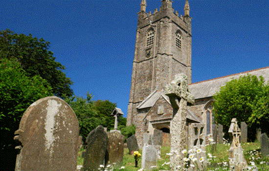 Looking up at St Andrew's Church in Stratton underneath a bright blue sky.