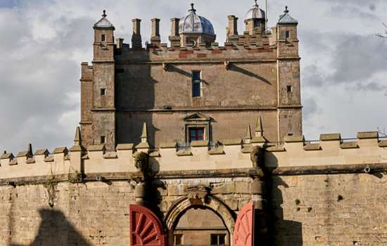 A view of Bolsover Castle with painted red open arched doors.